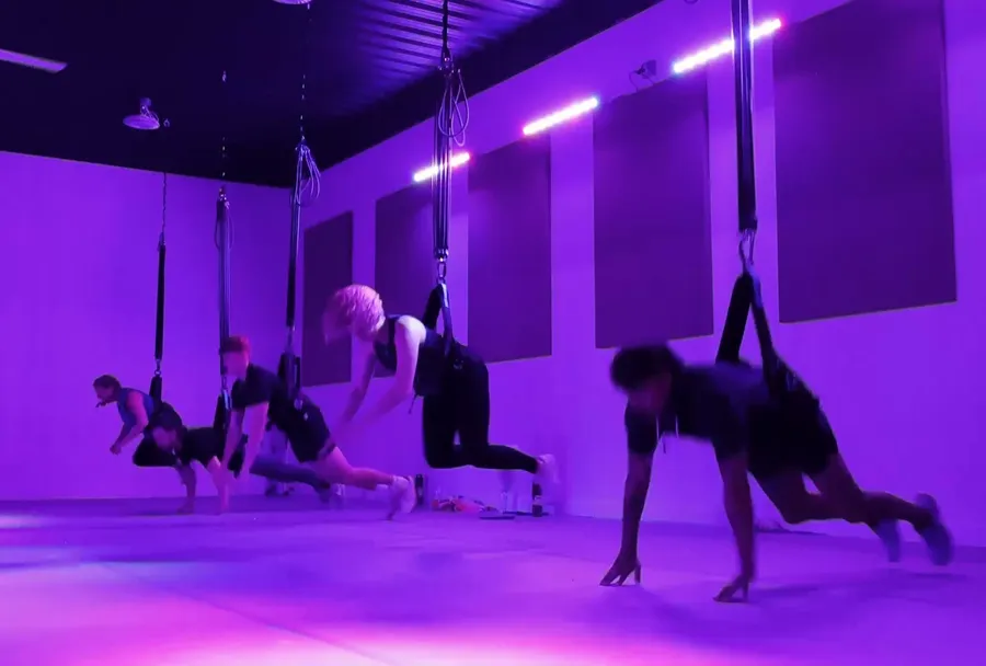 A class in harnesses moving together in the C.O.R.E. studio