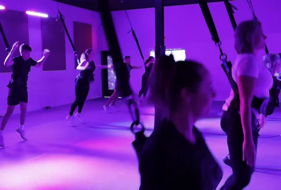 Members supported by bungee cords during a slower-paced class